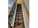 View of the staircase with stained hardwood railings and black metal spindles at 7562 Petrea Ln, Charlotte, NC 28227