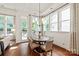 Inviting dining area with wood floors, stylish chandelier, and abundant natural light from large windows at 7913 Waverly Walk Ave, Charlotte, NC 28277