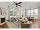 Bright, open-concept living area with hardwood floors, a fireplace, and large windows at 7913 Waverly Walk Ave, Charlotte, NC 28277