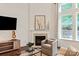 Living room fireplace with mounted TV and view of the landscaped backyard at 7913 Waverly Walk Ave, Charlotte, NC 28277