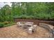 Charming outdoor patio with cushioned seating, stone retaining wall, and beautiful landscaping at 7913 Waverly Walk Ave, Charlotte, NC 28277