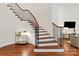 Elegant curved staircase with hardwood treads and iron railing leading to the upper level at 7913 Waverly Walk Ave, Charlotte, NC 28277