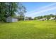 Wide shot of the backyard, showcasing a large grassy area and a storage shed, perfect for outdoor activities at 800 Old Little Rock Rd, Charlotte, NC 28214