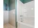 A bathroom featuring a tub/shower combo, tiled walls, and green painted accent walls at 800 Old Little Rock Rd, Charlotte, NC 28214