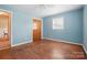 A brightly lit bedroom featuring a closet, hardwood floors, one window, and light blue painted walls at 800 Old Little Rock Rd, Charlotte, NC 28214