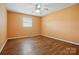 Bedroom with a window and hardwood floors, featuring orange painted walls and a ceiling fan at 800 Old Little Rock Rd, Charlotte, NC 28214