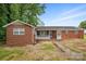 A quaint single story brick home with a white lattice porch and brick walkway in the front at 800 Old Little Rock Rd, Charlotte, NC 28214