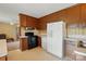 A retro kitchen with wood cabinets, an island and white appliances, plus view of the living room at 800 Old Little Rock Rd, Charlotte, NC 28214