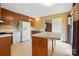 Retro kitchen with wood cabinets, white appliances, island and vintage wallpaper at 800 Old Little Rock Rd, Charlotte, NC 28214