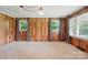 Living room featuring wood paneling, carpeted floors and multiple windows for natural light at 800 Old Little Rock Rd, Charlotte, NC 28214