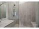 Bathroom shower with glass door, tiled walls, and a built-in seat at 8215 Houser St, Cornelius, NC 28031