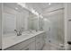 Bathroom with dual sinks and a glass enclosed shower with tiled walls at 8215 Houser St, Cornelius, NC 28031