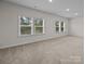 An airy bedroom with carpeted floors, three large windows, and natural light at 8215 Houser St, Cornelius, NC 28031