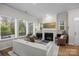 Bright and spacious living room with a fireplace, large windows, and stylish furniture at 8215 Houser St, Cornelius, NC 28031