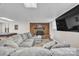 Basement living room with a brick fireplace and a large gray sectional at 827 River Hills Ct, Taylorsville, NC 28681