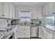Charming kitchen with white cabinetry, stainless steel appliances, and a view from the window at 827 River Hills Ct, Taylorsville, NC 28681