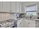 Bright kitchen with white cabinets, modern appliances, tile backsplash, and sleek countertops at 827 River Hills Ct, Taylorsville, NC 28681
