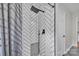 Modern bathroom shower featuring sleek, black hardware and eye-catching white herringbone tiling at 827 River Hills Ct, Taylorsville, NC 28681