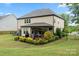 Landscaped backyard with a covered patio perfect for outdoor entertaining and dining at 9530 Hightower Oak St, Huntersville, NC 28078