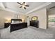 A bedroom features a tray ceiling, ceiling fan and neutral walls with carpet floors at 9530 Hightower Oak St, Huntersville, NC 28078