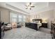 The bedroom showcases a tray ceiling, ceiling fan and two chairs by a sunny window at 9530 Hightower Oak St, Huntersville, NC 28078