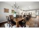 Dining room with rustic wood table, modern chandelier, and view to kitchen at 9530 Hightower Oak St, Huntersville, NC 28078