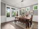 Bright dining room featuring hardwood floors, large windows, stylish lighting and a rustic wooden table at 9530 Hightower Oak St, Huntersville, NC 28078