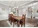 Dining room featuring hardwood floors, staircase, large windows and a rustic wooden table with seating for six at 9530 Hightower Oak St, Huntersville, NC 28078