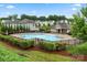 Community pool with lounge chairs surrounded by manicured landscaping and green space at 9530 Hightower Oak St, Huntersville, NC 28078