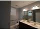 Elegant bathroom featuring double sinks, dark wood cabinets, accessible features, and a walk-in shower at 1000 E Woodlawn Rd # 107, Charlotte, NC 28209