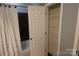 Bathroom includes a shelving unit, a bathtub-shower combo and a door at 1000 E Woodlawn Rd # 107, Charlotte, NC 28209