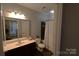 Bright bathroom features a vanity with ample counter space and a shower-tub combo with a white shower curtain at 1000 E Woodlawn Rd # 107, Charlotte, NC 28209