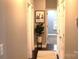 Inviting hallway with hardwood floors, neutral paint, and a decorative plant, leading to other rooms at 1000 E Woodlawn Rd # 107, Charlotte, NC 28209