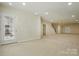 Spacious carpeted basement featuring a door to the exterior and staircase to upper level at 1030 Pinehurst Ln, Fort Mill, SC 29707