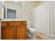 Cozy bathroom with wood cabinets, a toilet, and a shower with a white curtain at 1030 Pinehurst Ln, Fort Mill, SC 29707