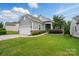Charming home featuring a two-car garage, stone accents, manicured lawn, and lush landscaping at 1030 Pinehurst Ln, Fort Mill, SC 29707