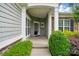 Inviting front porch with stone accents, white pillars, and a glimpse of the stylish entrance door at 1030 Pinehurst Ln, Fort Mill, SC 29707