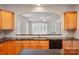 Bright kitchen features wood cabinets, granite countertops, black appliances and view to the living room at 1030 Pinehurst Ln, Fort Mill, SC 29707
