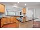 Kitchen featuring granite countertops, wood cabinetry, and seamless view to a bright and sunny living area at 1030 Pinehurst Ln, Fort Mill, SC 29707