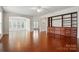 Open-concept living room with hardwood floors, a built-in wooden bookcase, and arched doorway to sunroom at 1030 Pinehurst Ln, Fort Mill, SC 29707