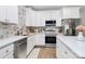 Bright kitchen featuring white cabinets, stainless steel appliances, and marble backsplash at 1066 Mclain Rd # 14, Kannapolis, NC 28083