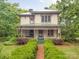 Charming two-story home with a covered porch, green metal roof, and a well-maintained front yard, blending historical charm at 1120 N College St, Mount Pleasant, NC 28124