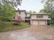 Spacious three-car garage with an attached upper level deck and beautiful landscaped surroundings on a rainy day at 1120 N College St, Mount Pleasant, NC 28124