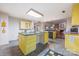 Open-concept kitchen with a central island, yellow cabinets, and modern appliances, leading to a dining area at 1120 N College St, Mount Pleasant, NC 28124