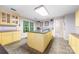 Well-lit kitchen with an island, yellow cabinetry, and modern appliances; perfect for cooking at 1120 N College St, Mount Pleasant, NC 28124