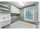 Functional laundry room with storage cabinets, a sink, and a bright window at 1120 N College St, Mount Pleasant, NC 28124