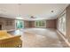 Spacious living room with neutral tones, tiled flooring, and natural light streaming through windows and glass doors at 1120 N College St, Mount Pleasant, NC 28124