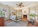 Comfortable bedroom with fireplace, ceiling fan, and warm hardwood floors at 1120 N College St, Mount Pleasant, NC 28124