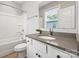 Well-lit bathroom features a modern vanity, gray countertop, and tub with shower at 1162 E 36Th St, Charlotte, NC 28205