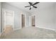 Spacious bedroom with plush carpeting, ceiling fan, and adjoining bathroom and closet at 1162 E 36Th St, Charlotte, NC 28205